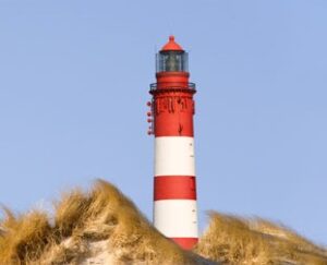 Ein rot-weiß gestreifter Leuchtturm auf Amrum.