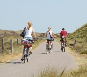 Drei Menschen fahren auf Amrum Fahrrad.