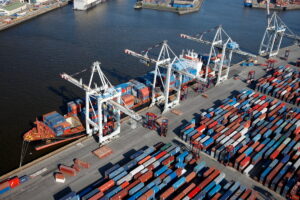 Die Kräne am Hamburger Hafen entladen Container von einem Schiff.