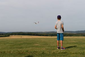 Der Junge Eike beobachtet seinen Modellflieger in der Luft.