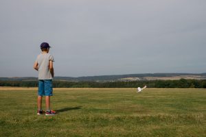 Der Junge Eike beobachtet seinen Modellflieger in der Luft.
