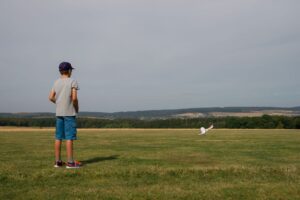 Der Junge Eike beobachtet seinen Modellflieger in der Luft.