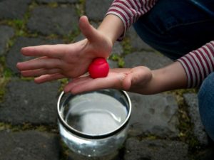 Ein Mädchen knetet einen kleinen Ball.