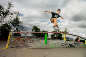 Der Junge Bennet skatet über ein Geländer.