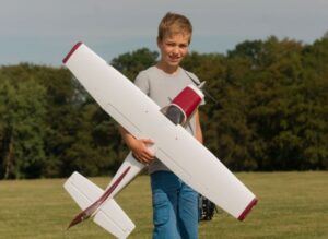 Der Junge Eike trägt seinen Modellflieger unter dem Arm.