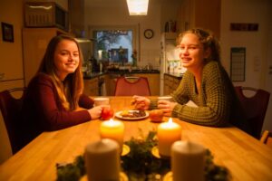 Die Mädchen Lotte und Marit sitzen zusammen an einem Tisch und trinken Tee.