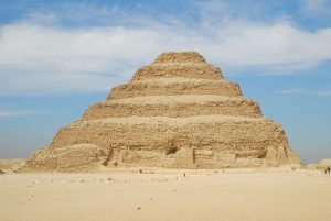 Das älteste Gebäude der Welt: Die Pyramide von Sakkara in Ägypten. Sie steht in einer Wüste.