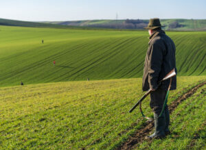 Ein Jäger steht auf einem Feld.