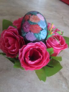 Ein bemaltes Ei mit vier Rosen darum, gebastelt von Julia Agalakowa aus Sibirien.