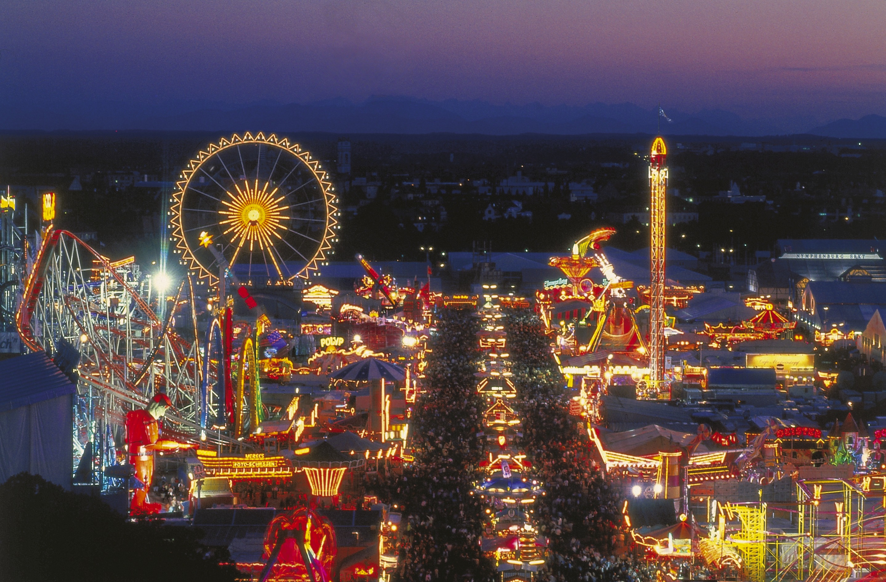 Die Wiesn vom Oktoberfest in München bei Nacht von oben her betrachtet.