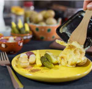 Raclette-Käse und Gemüse auf einem Teller.