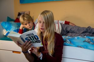 Das Mädchen Charlotte liest dem Jungen Philipp ein Buch vor.