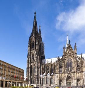 Der Kölner Dom von der Seite her. Über ihm strahlt ein blauer Himmel.