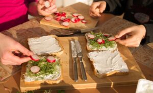 Vier bestrichene Toasts mit Quark, Joghurt, Kresse und Radieschen.