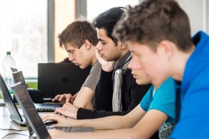 Vier Schüler schreiben Texte an Computern.