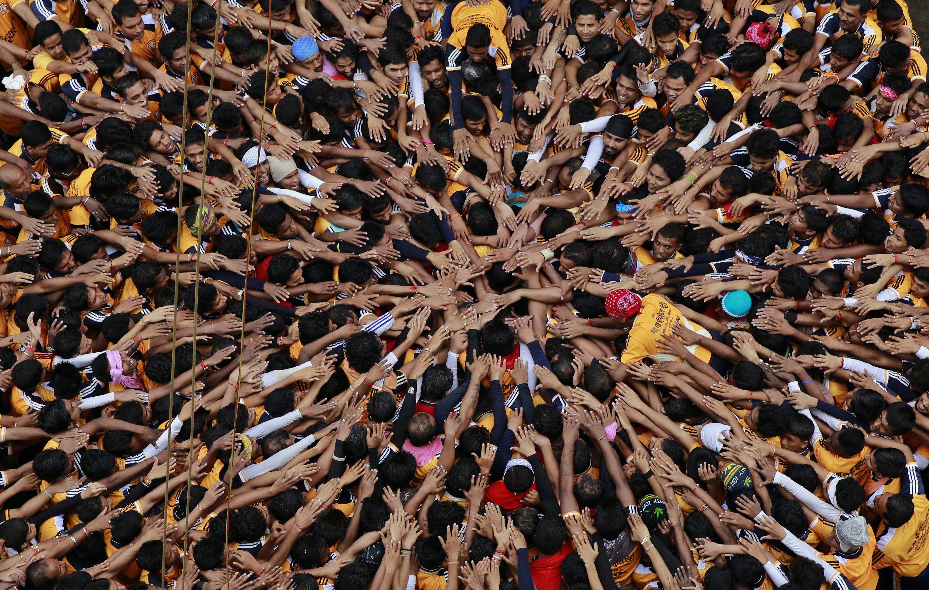 Indische Jugendliche drängen sich um das ¿Dahi Handi,¿ einen Topf mit Joghurt. Sie feiern das Janamashtami Fest in Mumbai, am 18. August 2014. Das Janmashtami Fest feiert die Geburt des Gottes Krishna.