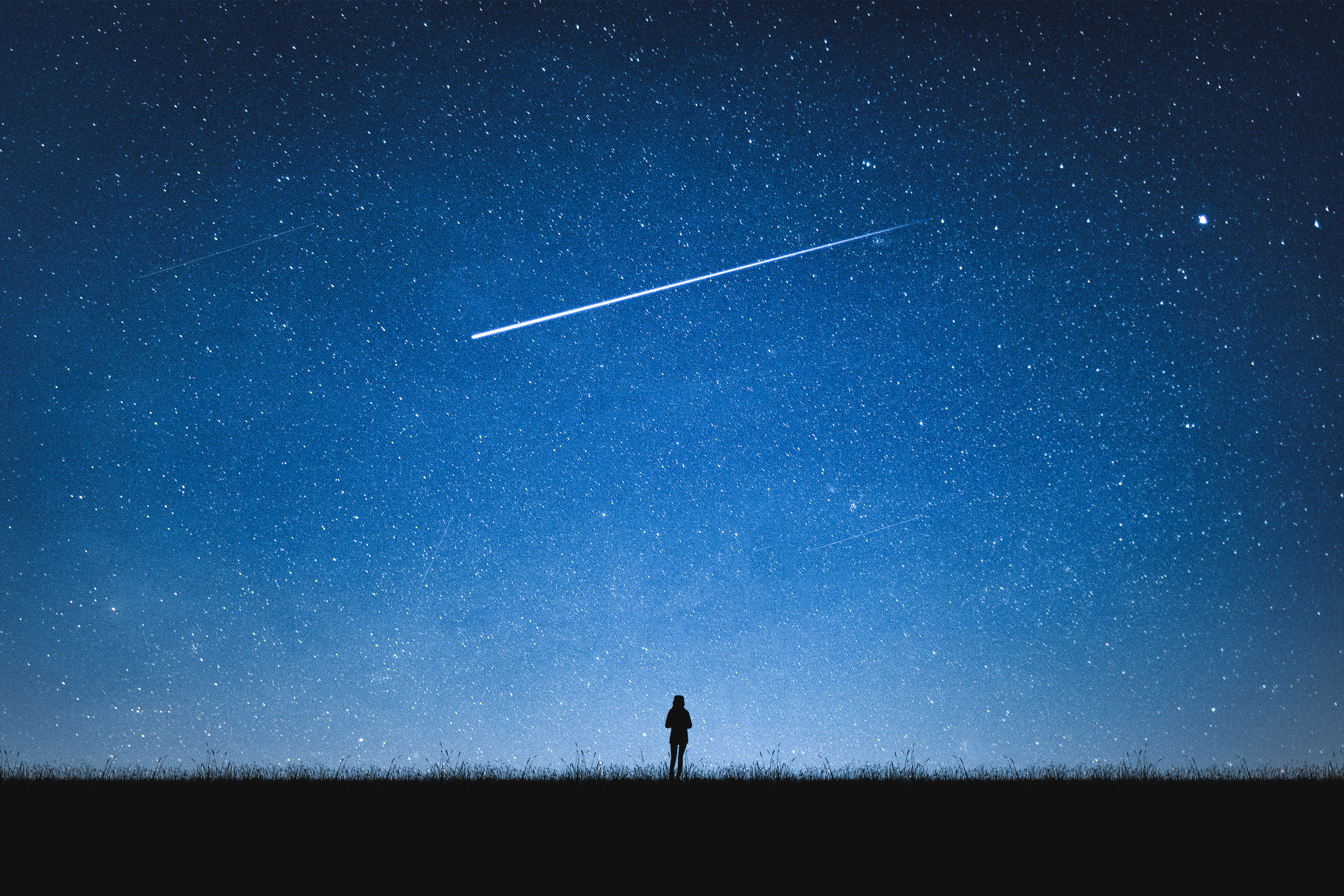 Ein blauer Nachthimmel mit Sternen und einer Sternschnuppe. Ein kleiner Mensch beobachtet den Himmel.
