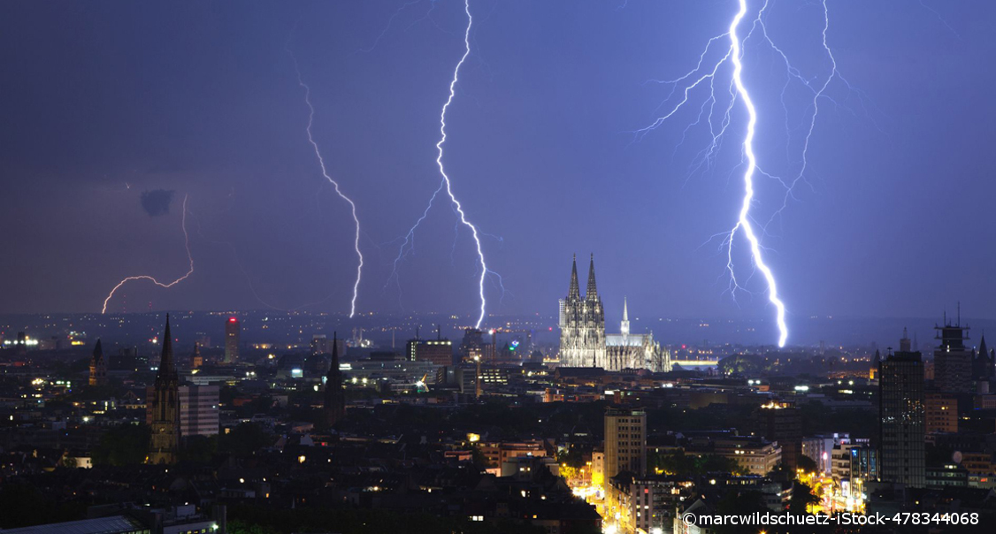 Ein Gewitter in Köln bei Nacht. Es schlagen große Blitze ein.