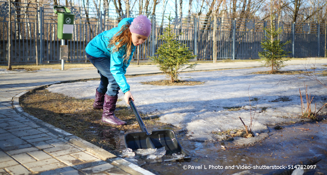 Frau schaufelt Schnee