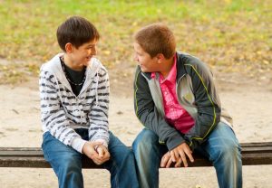 Zwei Jungs sitzen auf einer Parkbank.