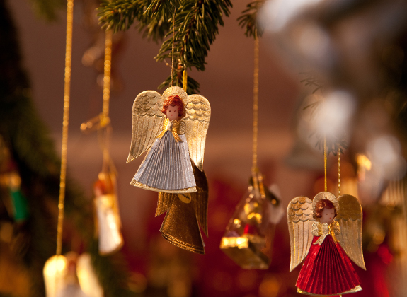 Deutsch üben mit dem Thema Weihnachtsmarkt. Mehrere Engel hängen von einem Tannenzweig.